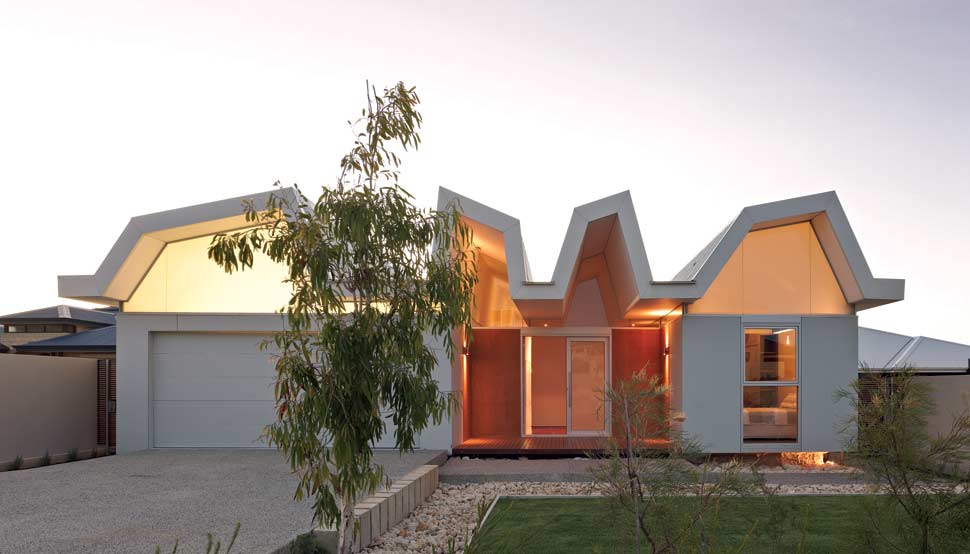 From the street, one can observe the composition of hovering platform, ribbons of glass and vaulted roof bays, which combine to set this house apart from its neighbours.