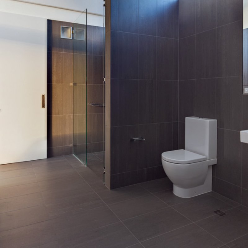 Ribbons of glass that offer views of the sky expand and contract to fill in the spaces beneath the undulating steel roof, as seen here in the master ensuite.